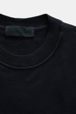 Nahaufnahme des Rundhalsausschnitts vom Stone Island Sweatshirt 'Ghost Piece' navy, elastische Baumwollqualität, weicher Griff, Regular Fit, tonales Kompass-Badge am Ärmel, fotografiert von oben.