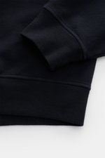 Nahaufnahme des Stone Island Sweatshirt 'Ghost Piece' navy von der Ärmel- und Saumseite, aus elastischer Baumwolle mit Rippbündchen und tonalem Kompass-Badge.