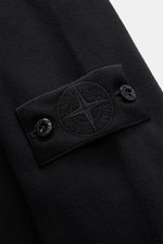 Stone Island Sweatshirt 'Ghost Piece' schwarz, Nahaufnahme seitlich, tonales Kompass-Badge, elastische Baumwollqualität, weicher Griff, Rippbündchen, Regular Fit.