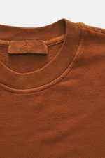 Stone Island Sweatshirt 'Ghost Piece' rostbraun in Nahaufnahme von oben, elastische Baumwolle, weicher Griff, Rundhalsausschnitt, tonales Kompass-Badge.
