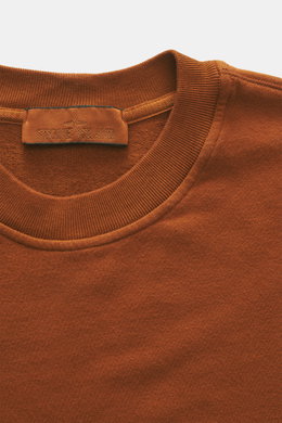 Stone Island Sweatshirt 'Ghost Piece' rostbraun in Nahaufnahme von oben, elastische Baumwolle, weicher Griff, Rundhalsausschnitt, tonales Kompass-Badge.