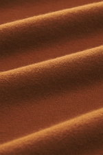 Stone Island Sweatshirt 'Ghost Piece' rostbraun, Detailaufnahme der elastischen Baumwollqualität mit weichem Griff aus der Ghost Collection, nah, Ton-in-Ton Kompass-Badge sichtbar.