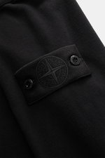 Nahaufnahme des schwarzen Stone Island Longsleeve Sweat-Poloshirt 'Ghost Piece' mit elastischem Baumwollsweat und STONE ISLAND-Patch am Oberarm, Detailansicht von schräg oben.