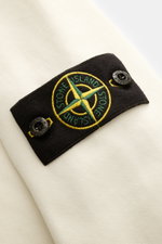 Stone Island Rundhals-Sweatshirt 'Basic Sweat' creme, Detailansicht des Kompass-Badges am Oberarm, weicher Baumwollstoff, Regular Fit, Rippbündchen.