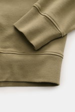 Nahaufnahme des Stone Island Rundhals-Sweatshirt 'Basic Sweat' oliv von unten schräg, zeigt Baumwollstoff, weichen Griff und Rippbündchen.