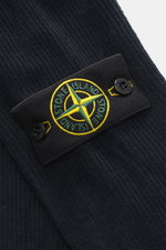 Nahaufnahme des typischen Kompass-Badges am Ärmel des Stone Island Cord-Sweatshirt navy aus Baumwollcord, weicher Griff, garment dyed, Regular Fit, gerippter Rundhalsausschnitt und komfortable Rippbündchen, fotografiert aus seitlicher Perspektive.
