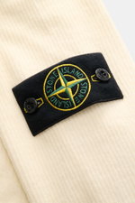 Close-up angled view of Stone Island Corduroy Sweatshirt cream showing the black compass badge with yellow and green embroidery on soft cotton corduroy fabric.

<p>This sweatshirt from STONE ISLAND is made from pure cotton corduroy, giving it a special tw