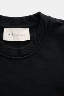 A close-up front view of the Ami Paris Crewneck Sweatshirt black showing the ribbed crew neckline and fabric label inside. Comfortable basic: The AMI PARIS sweatshirt made of pure cotton is the ideal companion for sporty looks. Sweat made of pure cotton, 