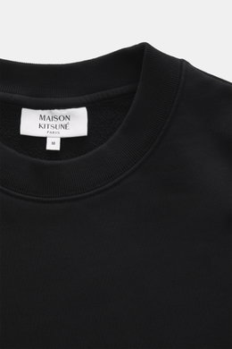 Nahaufnahme des Rundhalsausschnitts und Labels des Maison Kitsuné Sweatshirt schwarz, Sweat aus reiner Baumwolle, weicher Griff, Slim Fit, typisches Fuchs-Patch.