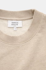 Close-up front view of Maison Kitsuné Beige Melange Sweatshirt showing round neckline and label inside collar in beige melange color.

<p>Cool essential from MAISON KITSUNÉ: With the typical fox patch on the chest, this sweater becomes a favorite piece in
