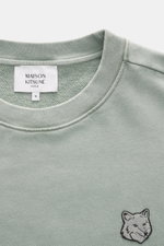 Nahaufnahme des mintgrünen Maison Kitsuné Sweatshirts aus reiner Baumwolle mit Rundhalsausschnitt und Fuchs-Patch auf der Brust, weicher Griff.