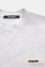 Jacquemus Sweatshirt 'Gros Grain' hellgrau meliert, Nahaufnahme von Rundhalsausschnitt, Regular Fit, Baumwolle, Overlock-Nähte, Rippbündchen, Logo-Stitching Brust
