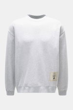 Frontale Nahaufnahme des Jacquemus Sweatshirt 'Torneo' hellgrau meliert mit Rundhalsausschnitt, Regular Fit, Patch am Saum, Logo-Stitching hinten, Rippbündchen, Sweat aus reiner Baumwolle und softer Innenseite.