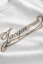 Nahaufnahme vom Jacquemus Sweatshirt 'Torneo' hellgrau meliert, Sweat aus reiner Baumwolle, softe Innenseite, Regular Fit, Rundhalsausschnitt, Patch am Saum, Logo-Stitching auf der Rückseite, komfortable Rippbündchen.