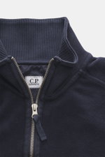 Nahaufnahme des C.P. Company Sweat-Troyer navy von oben, Sweat aus reiner Baumwolle, weicher Griff, Regular Fit, Troyer-Kragen mit Reißverschluss, aufgesetzte Tasche am Oberarm, labeltypisches Linsen-Detail, flexible Rippbündchen.