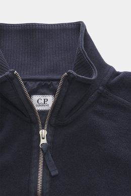 Nahaufnahme des C.P. Company Sweat-Troyer navy von oben, Sweat aus reiner Baumwolle, weicher Griff, Regular Fit, Troyer-Kragen mit Reißverschluss, aufgesetzte Tasche am Oberarm, labeltypisches Linsen-Detail, flexible Rippbündchen.