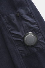 Nahaufnahme des C.P. Company Sweat-Troyer navy von schräg oben, Sweat aus reiner Baumwolle, weicher Griff, Regular Fit, Troyer-Kragen mit Reißverschluss, aufgesetzte Tasche am Oberarm, labeltypisches Linsen-Detail, flexible Rippbündchen.