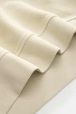 C.P. Company Sweat-Troyer sand, Detailfoto von weichen Baumwollstoffen, mit flexiblem Rippbündchen aus Nahaufnahme, Regular Fit, Troyer-Kragen, Reißverschluss, Oberarmtasche, labeltypisches Linsen-Detail.