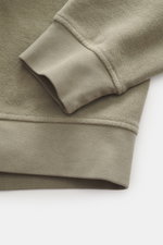Nahaufnahme des C.P. Company Sweatshirt salbei von unten, zeigt weichen Baumwollstoff, flexible Rippbündchen und Inside-Out-Design.