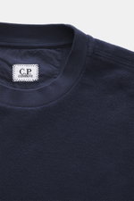 Nahaufnahme des Rundhalsausschnitts und Labels eines C.P. Company Sweatshirt navy aus reiner Baumwolle mit softem Griff, fotografiert von oben.