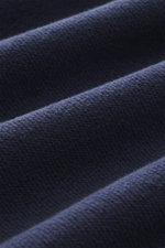 Alt-Tag (124 Zeichen): Nahaufnahme des navyfarbenen C.P. Company Sweatshirts aus reiner Baumwolle mit Inside-Out-Struktur und Linsen-Detail.