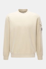 C.P. Company Sweatshirt sand, frontal aus leicht erhöhter Perspektive, Inside-Out-Design, reine Baumwolle, Ärmel-Tasche mit Linsen-Detail, Rundhals, Rippbündchen.