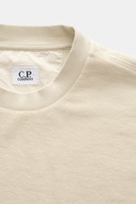 Nahaufnahme des sandfarbenen C.P. Company Sweatshirts aus reiner Baumwolle, Inside-Out-Design, Rundhalsausschnitt, weicher Griff, fotografiert von oben.