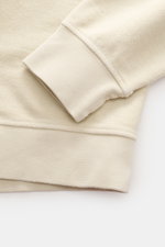 Nahaufnahme des Ärmelbündchens und der Oberarmtasche des C.P. Company Sweatshirt sand aus reiner Baumwolle im Inside-Out-Design.
