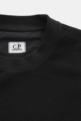 C.P. Company Sweatshirt schwarz, Nahaufnahme von Kragen und Label, aus reiner Baumwolle, Inside-Out-Design, softer Griff, Rundhalsausschnitt, flexible Rippbündchen.