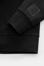 Nahaufnahme des schwarzen C.P. Company Sweat-Troyer Ärmels mit elastischem Rippbündchen und Logo-Patch, weich, Regular Fit.