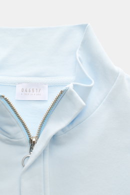 Nahaufnahme aus schräger Perspektive des pastellblauen 04651/ A trip in a bag Sweat-Troyer 'IF' mit Troyer-Kragen, verdecktem Zipper, weichem Griff, elastischer Baumwolle, Regular Fit, garment dyed, kleinem Weblabel, flexiblen Rippbündchen und softer Inne