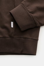Nahaufnahme des dunkelbraunen 04651/ A trip in a bag Sweat-Troyer 'IF' mit elastischem Rippbündchen, weichem Griff und kleinem Weblabel, fotografiert von oben. Sweat aus reiner Baumwolle, garment dyed, Regular Fit, Troyer-Kragen mit verdecktem Zipper, sof