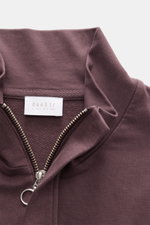 Nahaufnahme von Troyer-Kragen und Reißverschluss des 04651/ A trip in a bag Sweat-Troyer 'IF' bordeaux, Sweat aus reiner Baumwolle, elastisch, weicher Griff, garment dyed, Regular Fit, kleines Weblabel, flexible Rippbündchen, softe Innenseite, fotografier