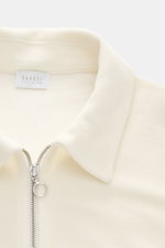 Nahaufnahme von 04651/ A trip in a bag Troyer 'CW Zip Polo' creme, Regular Fit mit klassischem Troyer-Kragen, innenliegender Brusttasche, weichem Griff, Woll-Baumwoll-Mix und kleinem Weblabel in Seitennaht.
