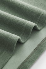 Nahaufnahme des Materials in salbeigrün, weicher Griff, Mix aus Wolle und Baumwolle, Detailansicht von innenliegender Brusttasche, Regular Fit, klassischer Troyer-Kragen, kleines Weblabel in Seitennaht, 04651/ A trip in a bag Troyer 'CW Zip Polo' salbei.