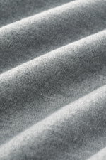 Nahaufnahme des weichen, graumelierten Circolo 1901 Woll-Sweatshirts aus reiner Schurwolle mit feinem Stitching, Perspektive auf die Textur.