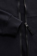Stone Island Sweatjacke dark navy aus reiner Baumwolle, garment dyed, mit robustem Reißverschluss, Stehkragen, Kängurutasche, Kompass-Badge, Rippbündchen, Detailaufnahme von vorne.