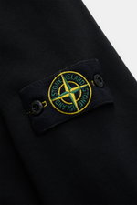 Close-up view of the Stone Island Sweatjacke schwarz sleeve showing the typical compass-badge on soft black cotton fabric.

<p>Entspanntes Basic von STONE ISLAND: Mit sportiver Lässigkeit begleitet uns die stückgefärbte Sweatjacke aus softer Baumwolle bei