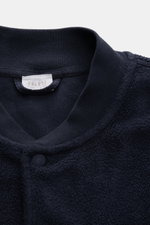 Nahaufnahme des oberen Bereichs des 04651/ A trip in a bag Fleece-Blouson navy mit typischem Blousonkragen aus Rippstrick, Druckknopfleiste, weichem Fleece aus reiner Baumwolle.