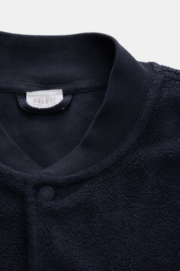 Nahaufnahme des oberen Bereichs des 04651/ A trip in a bag Fleece-Blouson navy mit typischem Blousonkragen aus Rippstrick, Druckknopfleiste, weichem Fleece aus reiner Baumwolle.