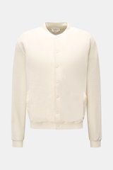 Frontale Nahaufnahme des 04651/ A trip in a bag Fleece-Blouson offwhite mit Slim Fit, weichem Baumwollfleece, Druckknopfleiste, Blousonkragen, schrägen Hüfttaschen und komfortablen Rippbündchen.