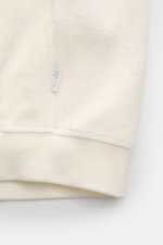 Nahaufnahme des Bündchens vom 04651/ A trip in a bag Fleece-Blouson offwhite aus weichem Baumwollfleece mit Weblabel in Seitennaht.