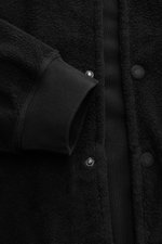 Close-up front view of the black 04651/ A trip in a bag Fleece blouson, showing pure cotton fleece, soft feel, slim fit, snap button placket, rib knit blouson collar, angled hip pockets, ribbed bands, and woven side label.