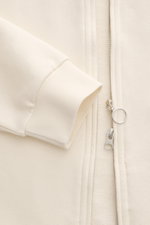 Close-up front view of the 04651/ A trip in a bag Sweatjacke 'CL Bomber' creme showing soft ribbed cuffs, garment-dyed fabric, and robust two-way zipper.