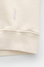 Close-up view of the hem and small fabric label of the 04651/ A trip in a bag Sweatjacke 'CL Bomber' creme, showing its soft organic cotton and linen mix with garment-dyed finish and ribbed cuffs.

<p>Entspannt unterwegs: Die Sweatjacke 'CL Bomber' von 04