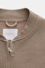 Close-up front view of 04651/ A trip in a bag Sweatjacke 'CL Bomber' taupe showing the garment-dyed fabric, ribbed collar, and metal two-way zipper with ring pull.

Description: <p>Entspannt unterwegs: Die Sweatjacke 'CL Bomber' von 04651/ A TRIP IN A BAG