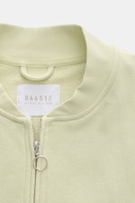 Close-up front view of 04651/ A trip in a bag Sweatjacke 'CL Bomber' pastellgrün in pastel green with garment-dyed finish, robust two-way zipper, and typical blouson collar.

<p>Entspannt unterwegs: Die Sweatjacke 'CL Bomber' von 04651/ A TRIP IN A BAG ko