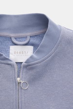 Close-up front view of the collar and zipper of the 04651/ A trip in a bag Sweat jacket 'CL Bomber' lavender, showcasing its garment-dyed organic cotton and linen blend with a soft feel, robust two-way zip with ring pull, signature blouson collar, slanted