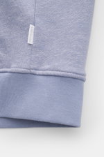 Close-up view of the cuff and small woven label on the 04651/ A trip in a bag Sweat jacket 'CL Bomber' lavender, showing soft organic cotton and linen blend fabric with a garment-dyed finish.

<p>Relaxation on the move: The sweat jacket 'CL Bomber' by 046