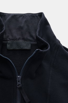 Nahaufnahme der Stone Island Sweatjacke 'Ghost Piece' navy mit Stehkragen, Reißverschluss und tonalem Kompass-Badge aus elastischer Baumwolle, soft und garment dyed.